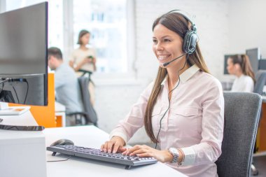 Çağrı merkezinde çalışan kulaklıklı güzel müşteri hizmetleri operatörü