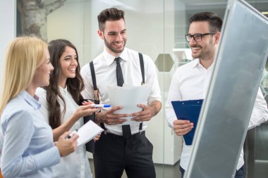Başarılı iş adamlarından oluşan bir ekip yönetim ofisinde toplantı düzenliyor.