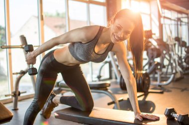 Vücut geliştiren kadın spor salonunda halterleri kaldırıyor..
