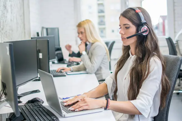 İş yerinde dizüstü bilgisayarda çalışan kadın müşteri destek operatörü