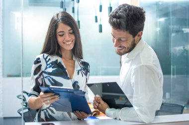 İş ortaklarının modern ofiste belgeyi tartışmalarını cam çerçevesinde izlemek