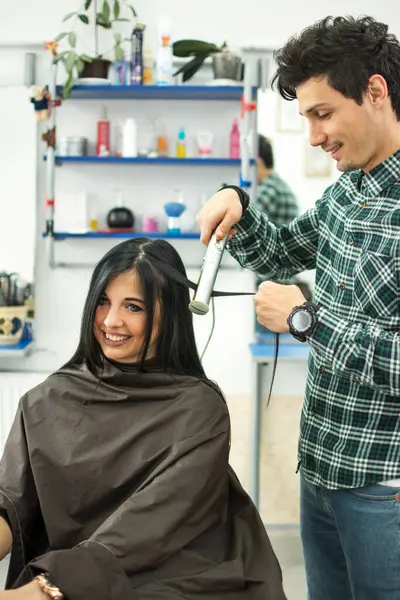 Young Male Stylist Using Hair Straightener Woman Salon — Stock Photo, Image