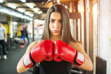 Spor salonunda boks eldivenli genç fitness kızı.