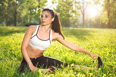 Kız dışarıda esneme egzersizleri yapıyor.