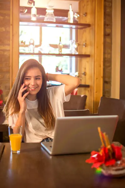 Bir Kafede Dizüstü Bilgisayarın Altında Oturan Genç Bir Kız Cep — Stok fotoğraf