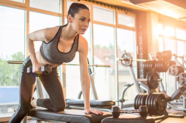 Sıska, genç ve güzel kız sağlık kulübünde ağırlıklarla ısınıyor..