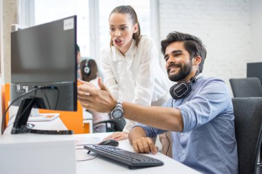 İş kadını ve erkek ofis bilgisayarında projeyi tartışıyor.