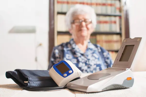 Blood Pressure Monitors Table Blurred Senior Woman Background — Stock Photo, Image