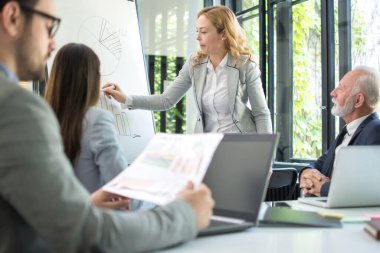 Takım lideri kadın konferans salonunda sunum yapıyor..