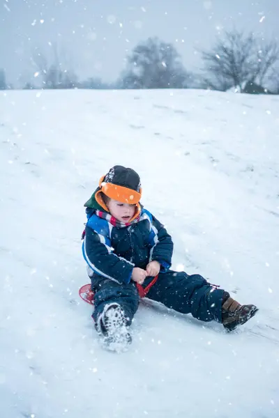 Küçük Çocuk Kar Yağarken Kızakla Gezmekten Hoşlanıyor — Stok fotoğraf