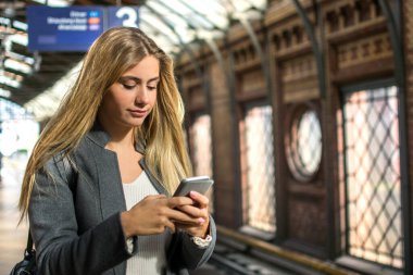 Tren istasyonunda cep telefonu kullanan bir kızın portresi.