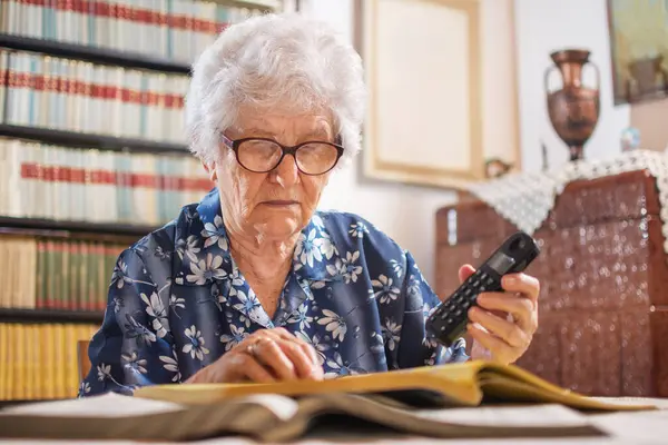 Senior Woman Searching Book Services Holding Telephone — Stock Photo, Image