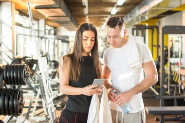 Spor salonunda çalışan ve akıllı telefon kullanan arkadaşlar..