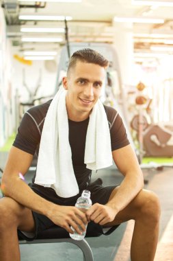 Şişe su ve spor olarak çalışma sonra molası havlu ile yakışıklı adam.