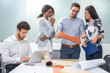 Mimarlar takımı ofiste plan üzerinde birlikte çalışıyor..