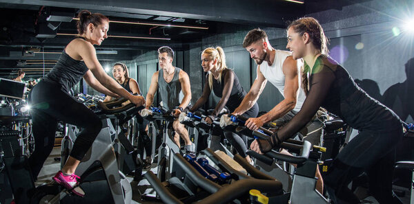 Group of sporty people on cycling class.