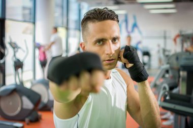 Spor salonunda kameraya yumruk atan yakışıklı bir adamın portresi..