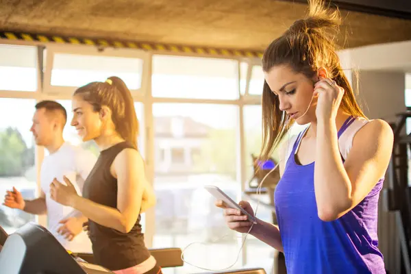 Junge Frau Hört Musik Auf Smartphone Während Sie Fitnessstudio Auf — Stockfoto
