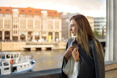 Berlin, Almanya 'da nehir manzarasının tadını çıkaran genç bir kadın.,