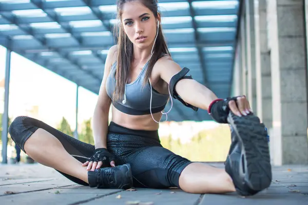 stock image Sporty woman stretching hamstring leg muscles during outdoor workout