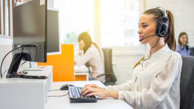 İş yerinde kulaklık takan telefon operatörü kadını destekle.
