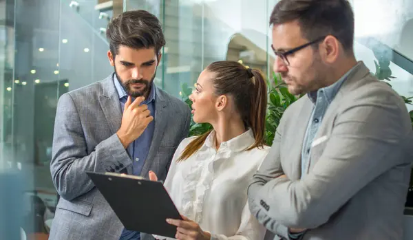 İş adamları ofiste belgeleri tartışıyor.