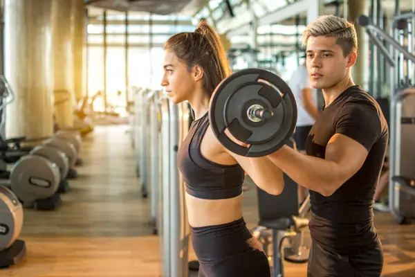 Attractive Young Woman Lifting Heavy Weights While Her Personal Trainer — Stock Photo, Image