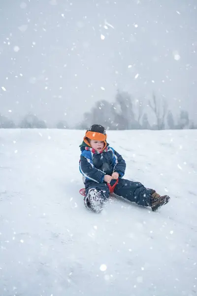 Küçük Çocuk Kar Yağarken Kızakla Gezmekten Hoşlanıyor — Stok fotoğraf