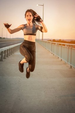 Açık havada başarılı bir antrenmandan sonra atlayan sporcu kız.