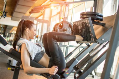 Spor salonundaki spor salonunda kaslarını çalıştıran formda genç bir sporcunun yan görünüşü..