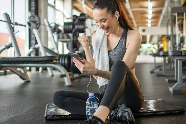 Cheerful Young Sporty Girl Holding Smartphone Celebrating Her Success — Stock Photo, Image