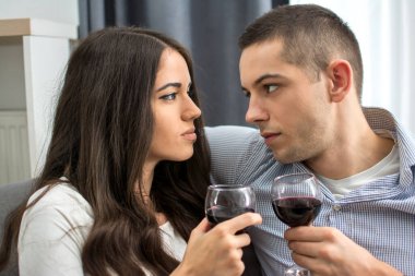 Kırmızı şaraplı genç çiftin romantik bir randevusu var. Erkek arkadaşını baştan çıkaran genç bir kadın.