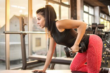 Spor salonunda genç seksi kadın halter..