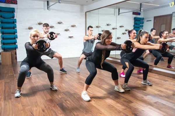 Spor Yapan Kadınlar Erkekler Sağlık Kulübünde Ağırlıklarla Birlikte Egzersiz Yapıyorlar — Stok fotoğraf