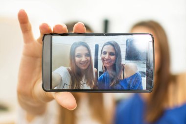 Arkadaşlar akıllı telefonlarıyla kendi portresini çekiyorlar.
