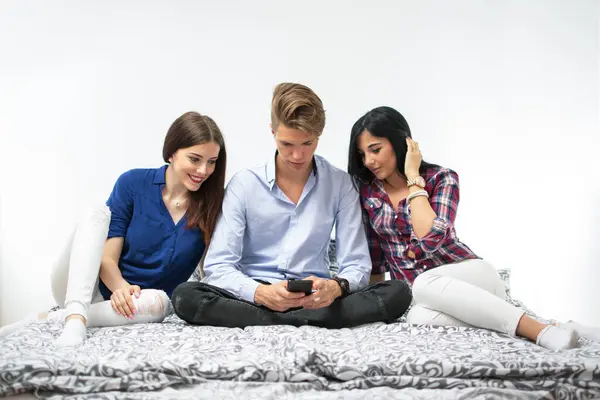 Três Amigos Sentados Cama Com Smartphone Casa — Fotografia de Stock