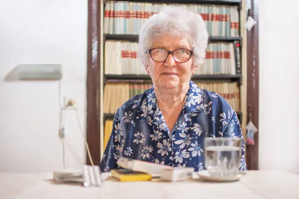 Alte Frau Sitzt Hause Tisch Voller Medikamente — Stockfoto