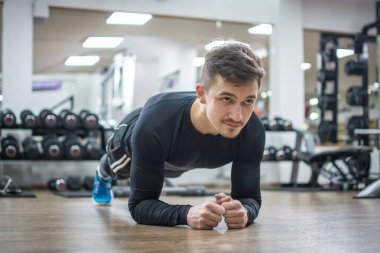 Spor salonundaki kaslı genç adam..