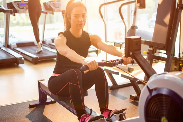 Sportliches Mädchen Trainiert Fitnessstudio Auf Einem Rudergerät — Stockfoto