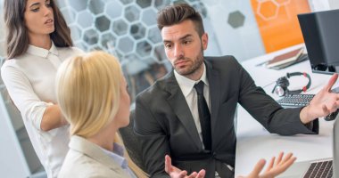 İş adamı, kadın meslektaşlarıyla ofiste tartışıyor.