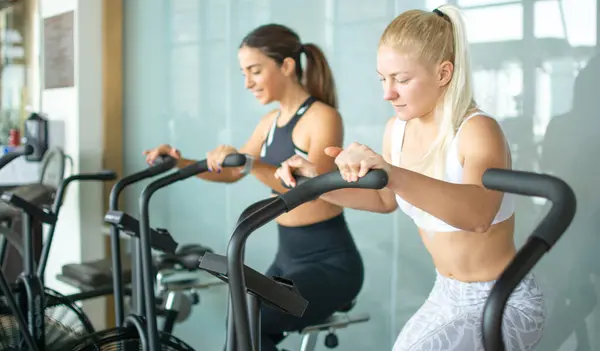 Attractive Young Fitness Women Working Out Together Elliptical Trainer Gym — Stock Photo, Image