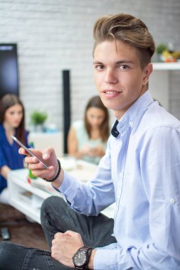 Genç adam akıllı telefon kullanıyor.