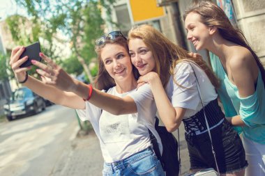 Genç kızlar şehrin sokaklarında selfie çekiyorlar..