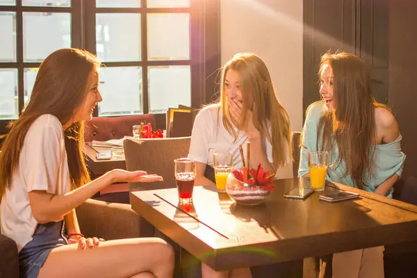 Três Lindas Jovens Mulheres Conversando Sorrindo Enquanto Bebem Sucos Restaurante — Fotografia de Stock