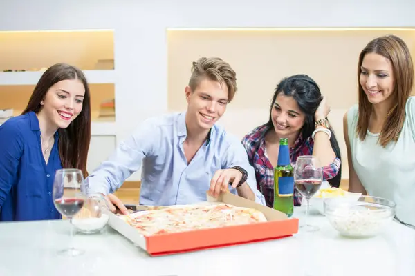 Smiling friends eating pizza at home