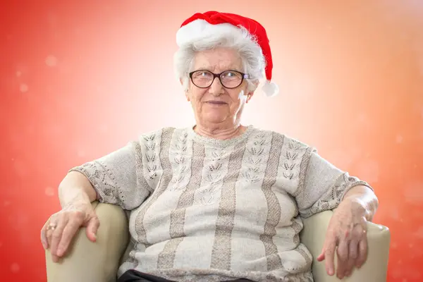 Gelukkig Senior Vrouw Met Rode Kerstmannen Hoed Zitten Bank Tegen — Stockfoto