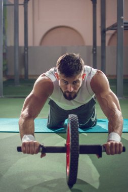 Yakışıklı sporcu, karın kaslarını çalıştırıyor ve dört gözle bekliyor..