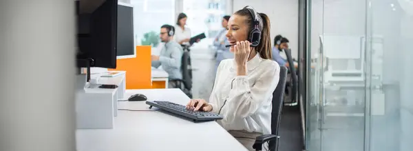 Smiling Businesswoman Using Computer Listening Client Headset Call Center Office — Stock Photo, Image
