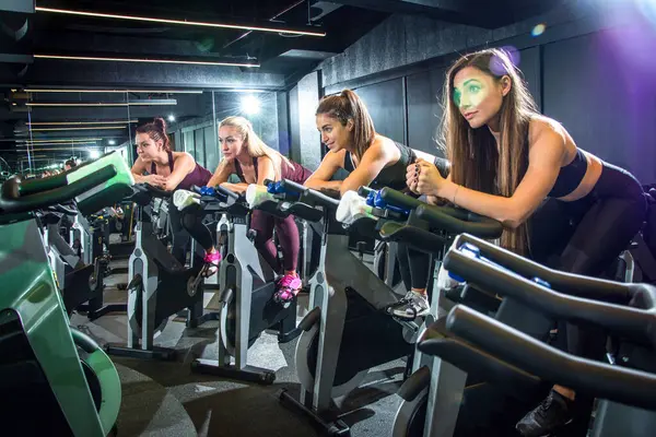 Sporty Girls Riding Fitness Bike Cycling Glass Gym — Stock Photo, Image