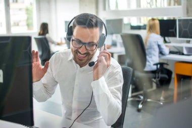 Çağrı merkezinde kulaklık takmış teknik destek yöneticisi istemciyle konuşuyor